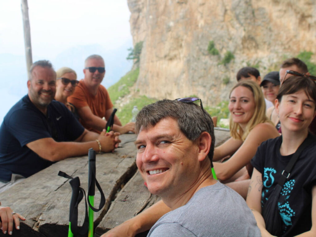 A group of people sitting at a table, taking a break during a tour