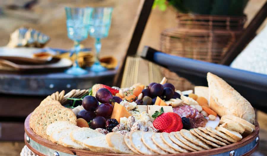 Luxury outdoor picnic with cheese board platter and wine glasses