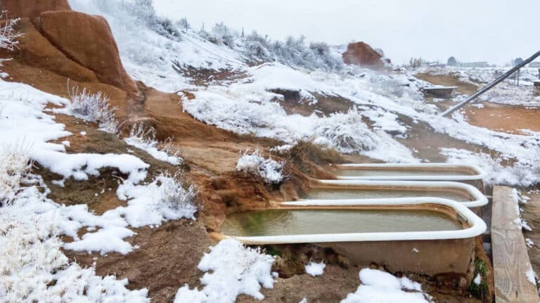 View of the three bathtubs filled with water at Mystic Hot Springs in Winter