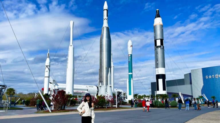 The author Lea Rose Allbaugh posing near the rockets at NASA’s Kennedy Space Center