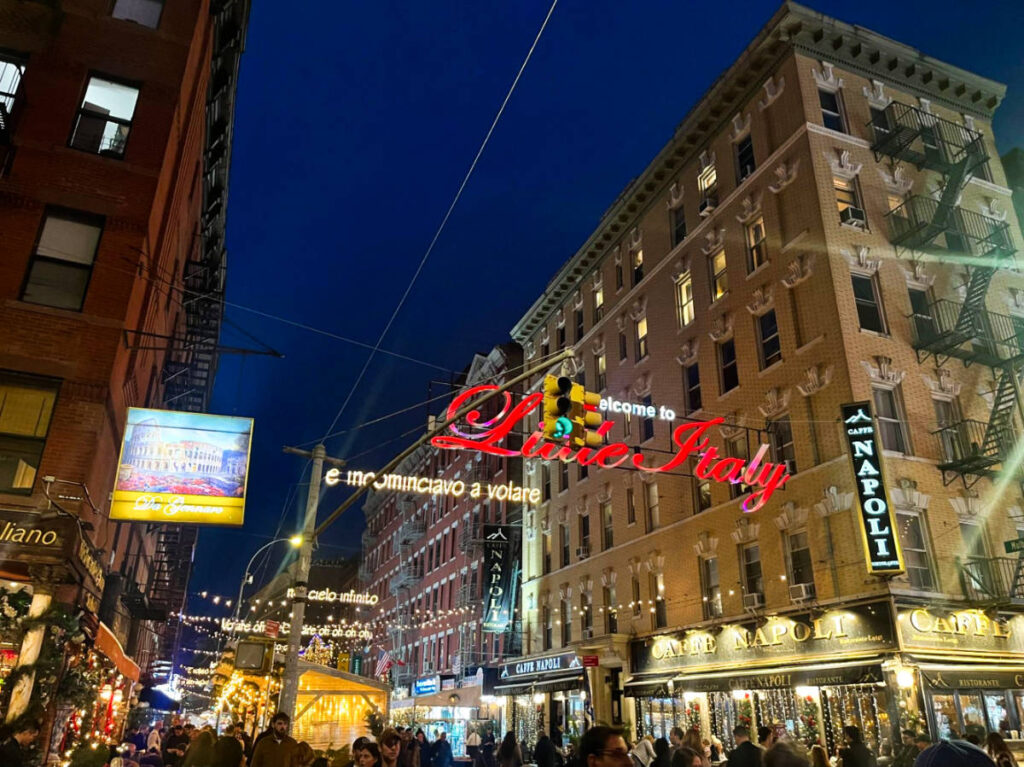 View of the illuminated signage of Little Italy over the the bustling street at night
