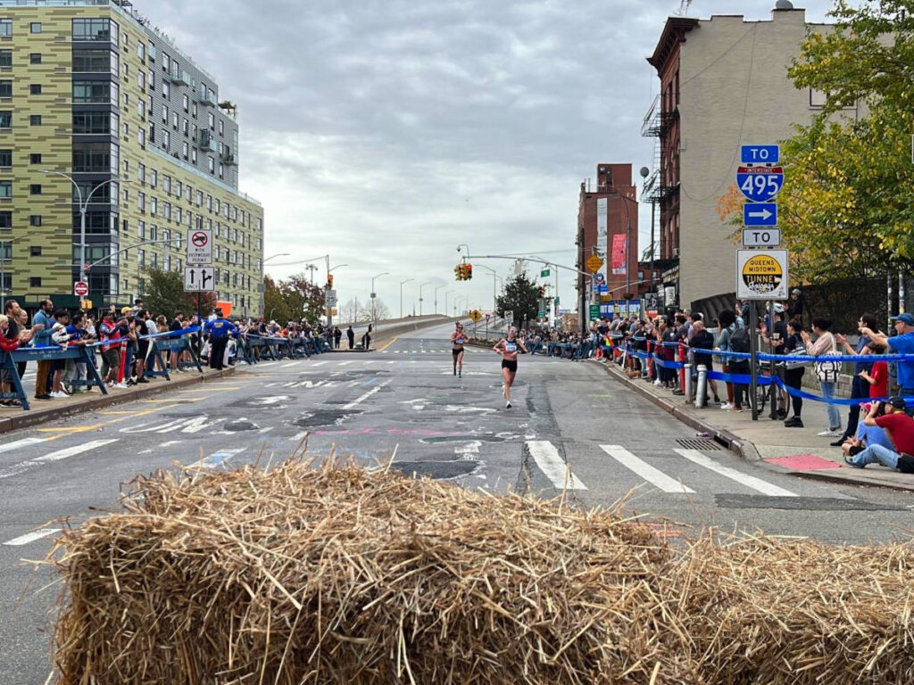 People cheering on the runners at NYC Marathon checkpoint in Queens