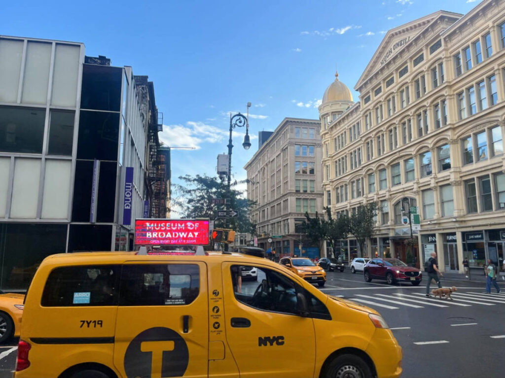 A yellow taxi cab driving around in NYC