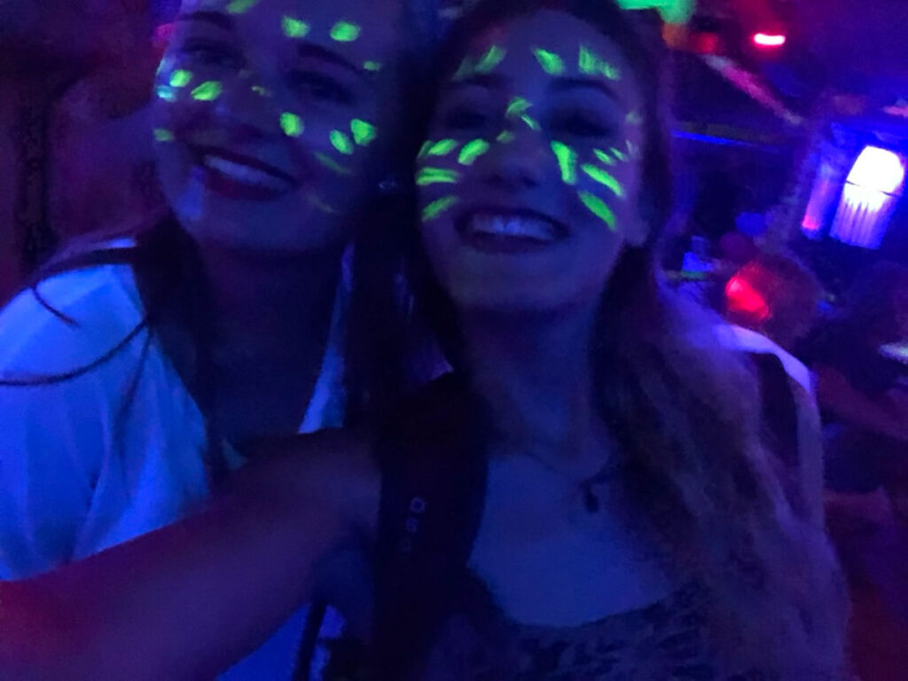 Author Sky and her friend taking a selfie with glow in the dark paint on their faces