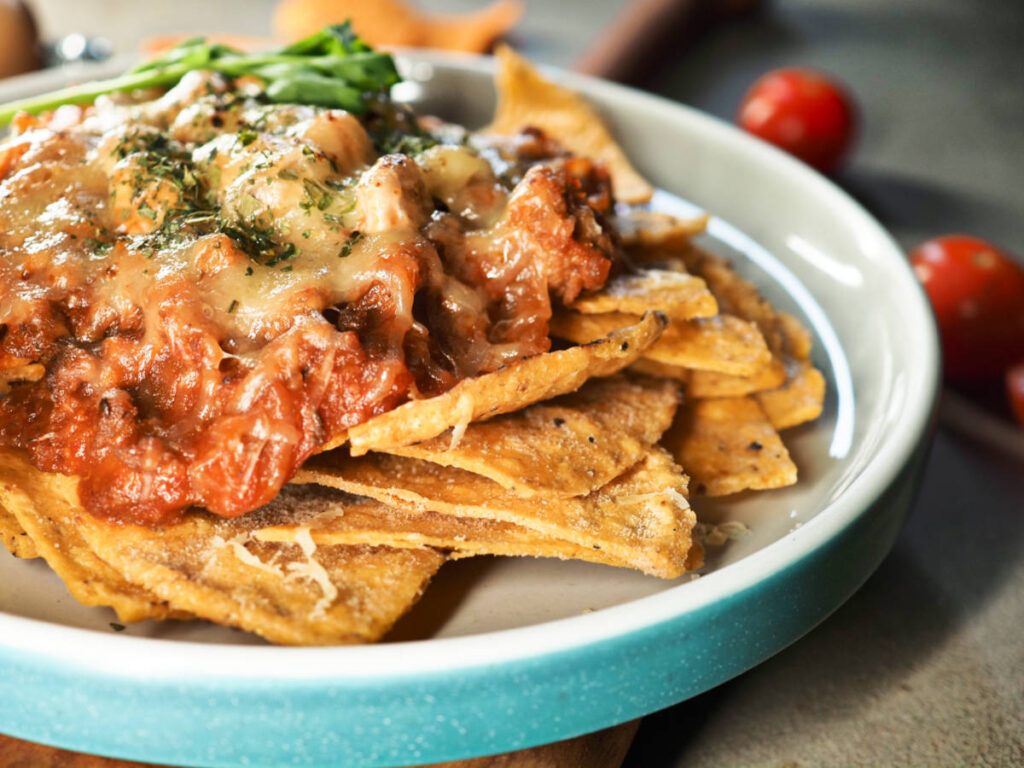 Closeup view of the tortilla chips topped with minced meat and cheese