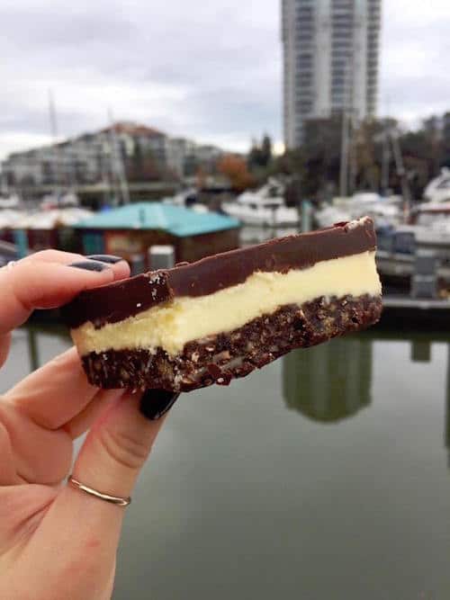 A Nanaimo bar is held against a backdrop of Nanaimo Harbor in Vancouver Island