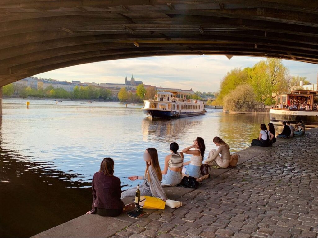 Groups of friends relaxing at Naplavka on a summer evening