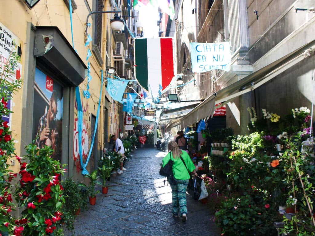 A woman walking along the narrow and busy street of Quartieri Spagnoli