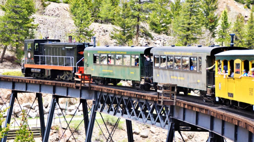 View of the colorful narrow gauge train running through the scenic view of Georgetown