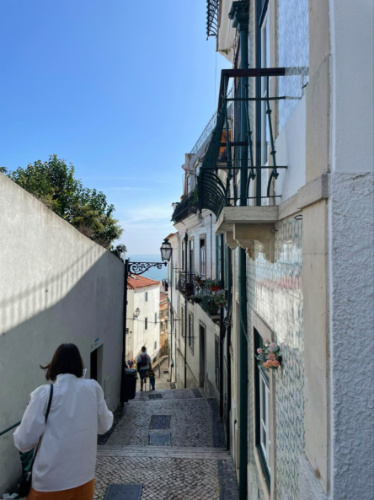 People going down the Narrow streets in the Alfama neighborhood