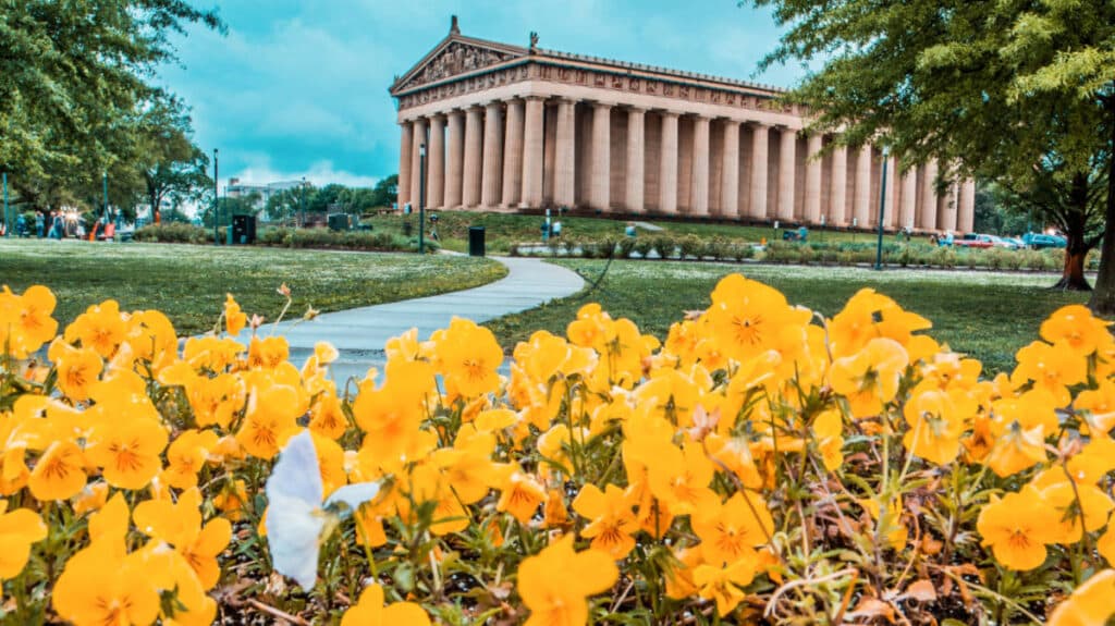 The Parthenon in Centennial Park with yellow flowers in the foreground