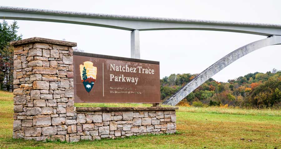 View of the Natchez Trace Parkway signage and the bridge on its bakground