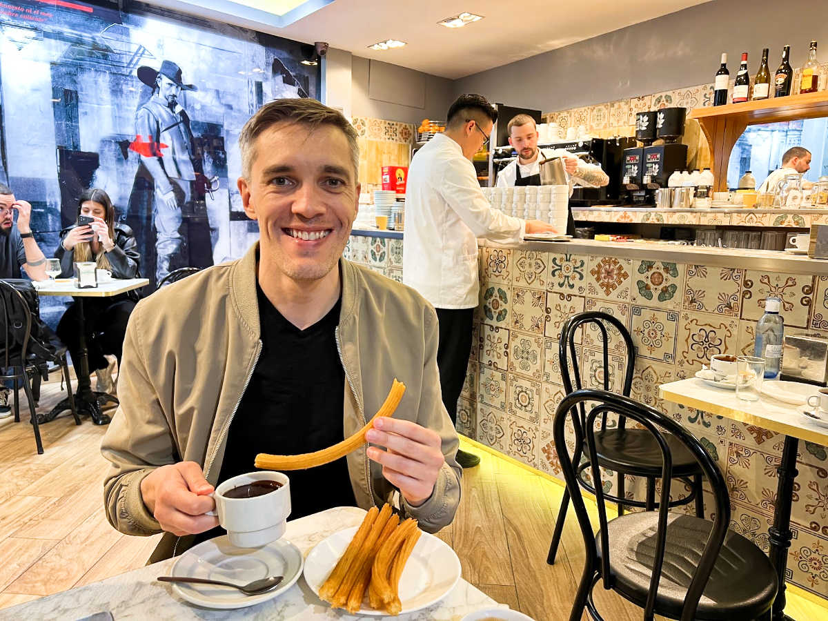 Travel Lemming’s founder Nate Hake holding a churros Chocolateria San Ginés