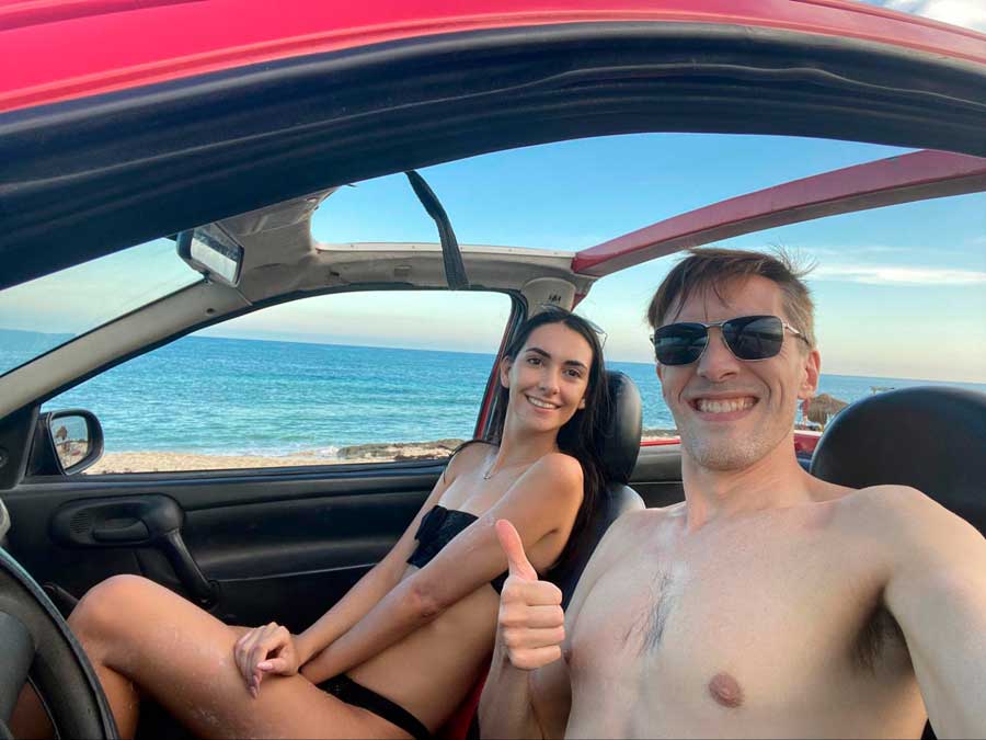 The author with his partner taking a photo inside a rental car