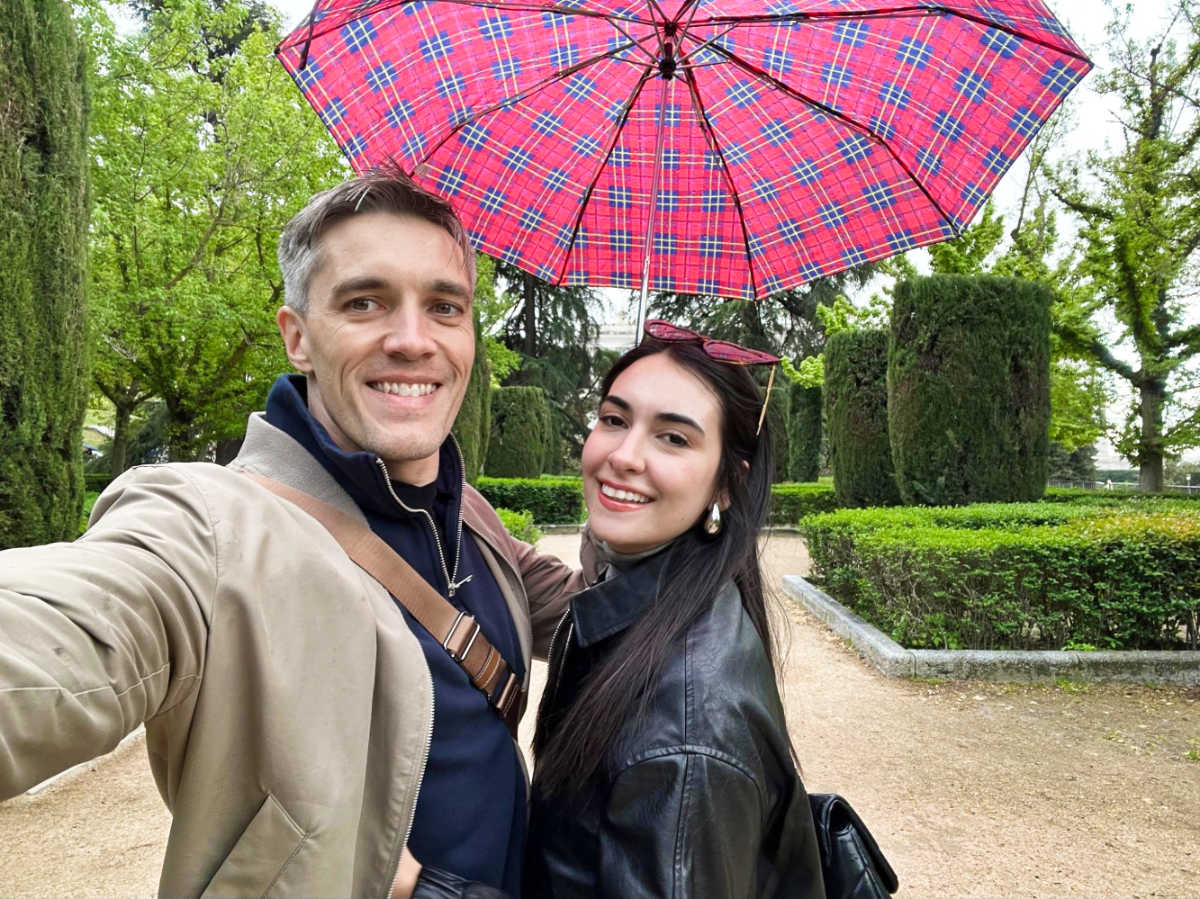 Travel Lemming’s founder Nate Hake and his partner Clara Kesseler holding an umbrella in the park