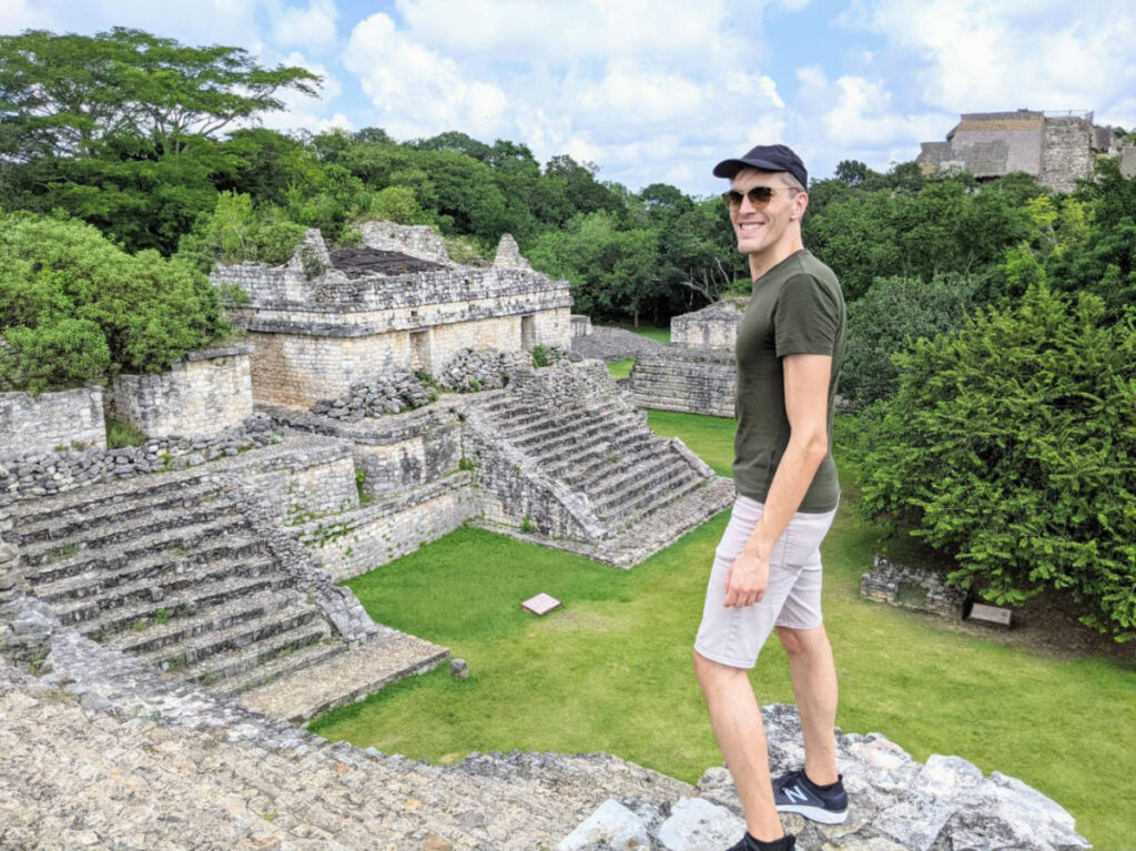 Travel Lemming founder, Nate Hake, smiling for a photo with an overlooking view of the Mayan ruins