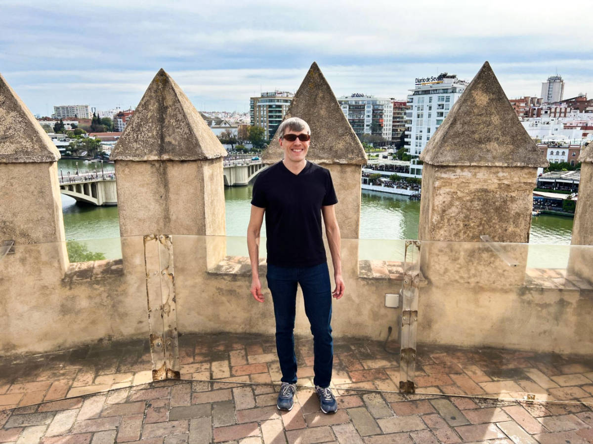 Travel Lemming Founder Nate, smiling for a photo atop the Torre del Oro