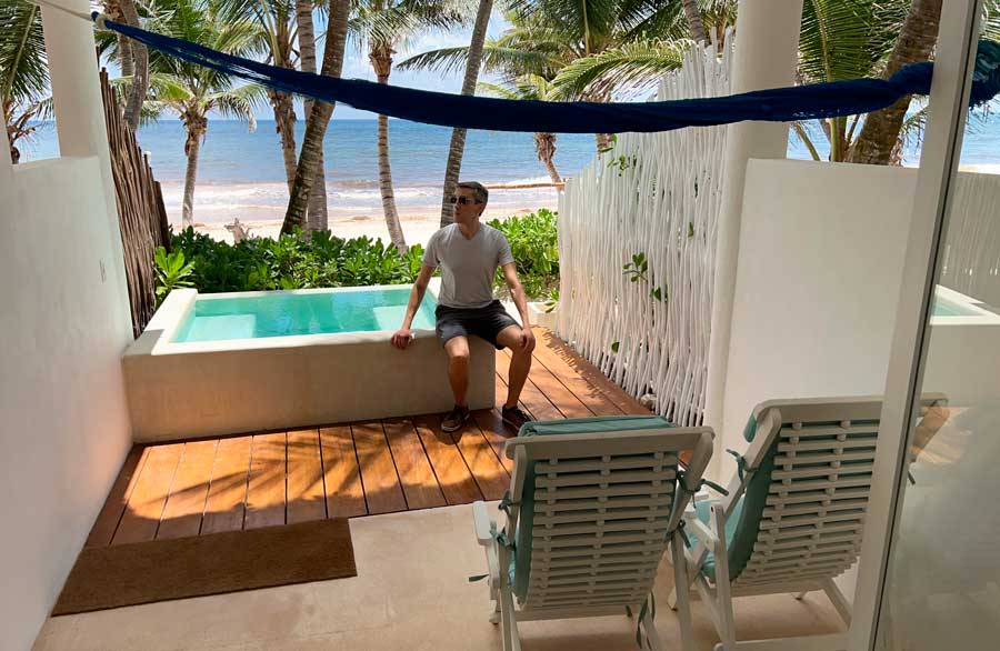 Nate sitting on the side of a jacuzzi in Cabañas Tulum Hotel