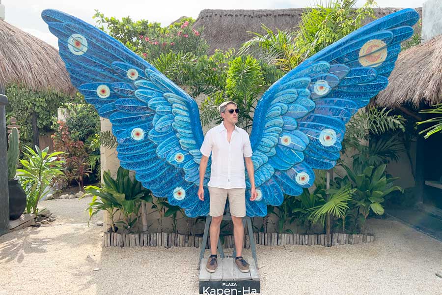 Nate posing for a photo with a colorful wings on his back