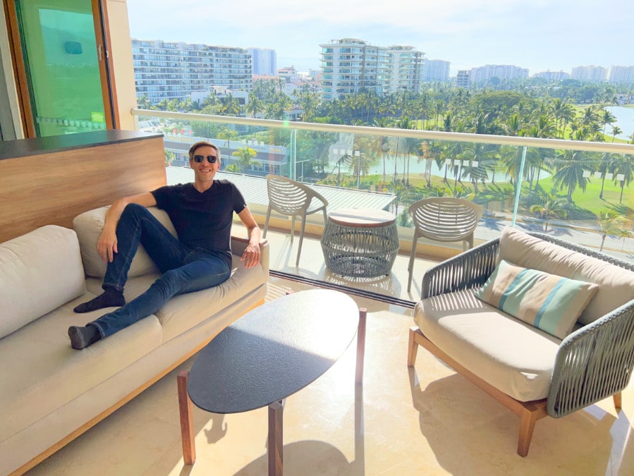 Nate in the balcony of Holiday Inn & Suites Puerto Vallarta and the overlooking view from it