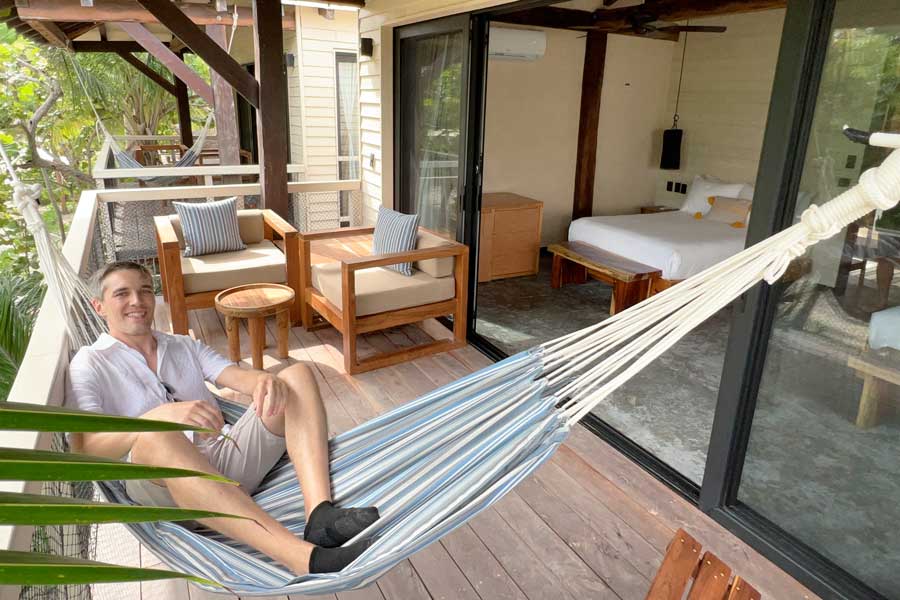 Nate sitting on a hammock on a balcony in Villa Pescadores