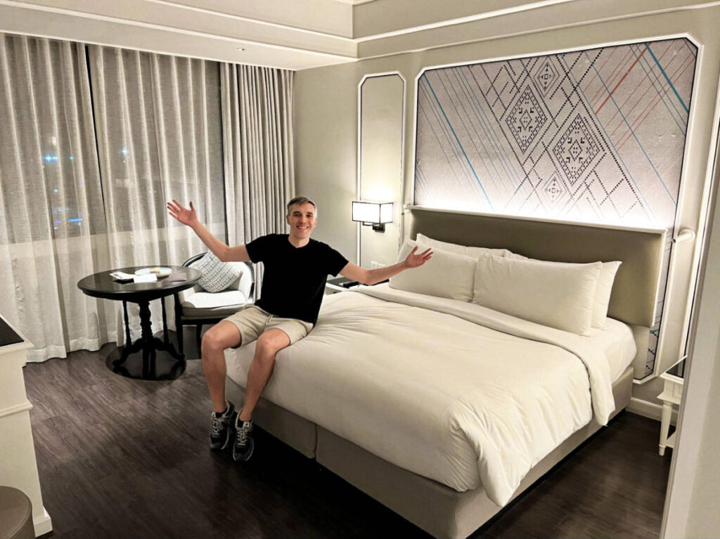 Travel Lemming founder Nate Hake sitting on the bed of Courtyard Phuket Town