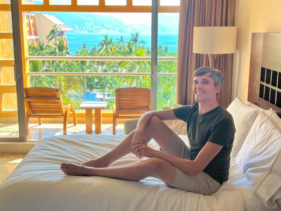 Nate sitting on the bed in Westin Puerto Vallarta