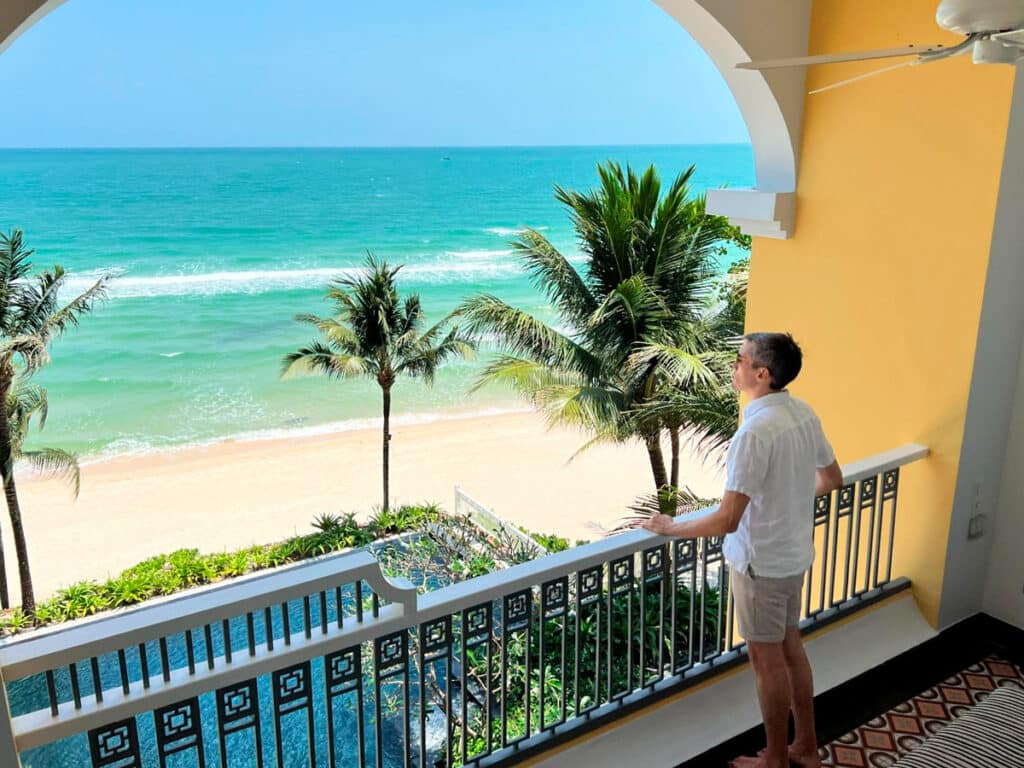 Nate admiring the beach view from their room balcony