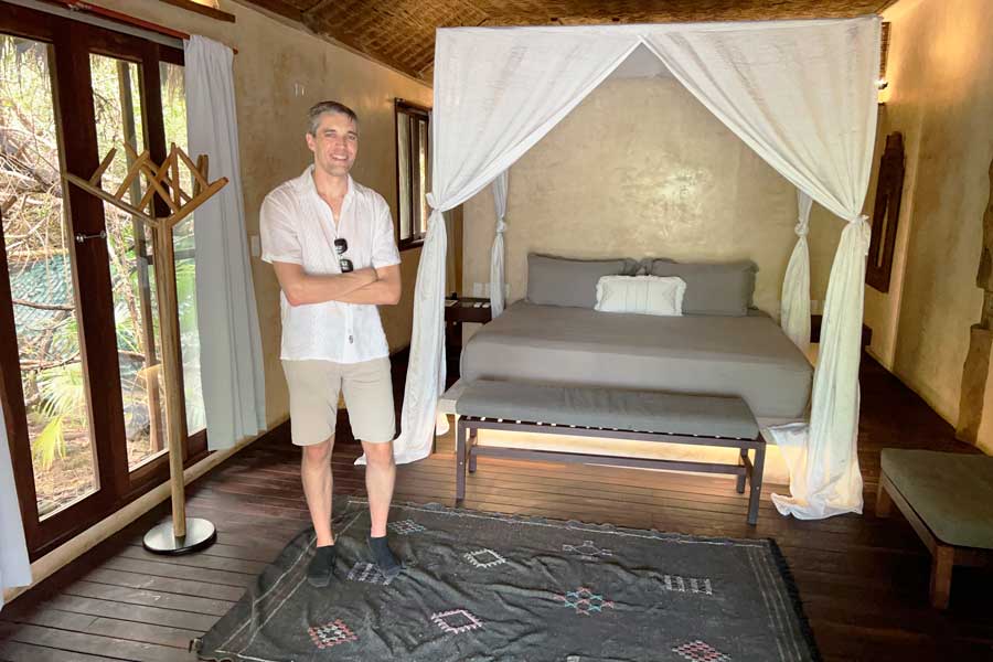 Nate standing beside a bed on Radhoo Tulum