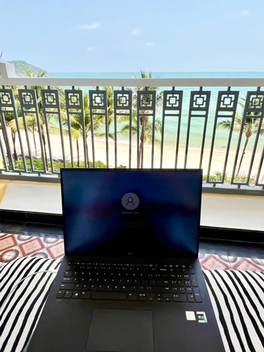 View of Nate on the balcony of their room at the resort while working