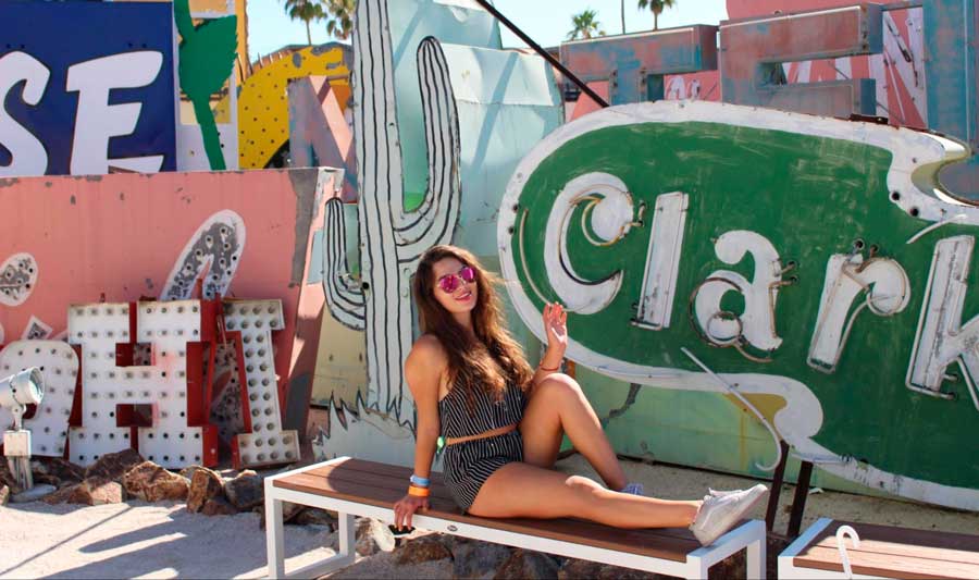 The author posing for a photo with the old neon signs in Neon Museum