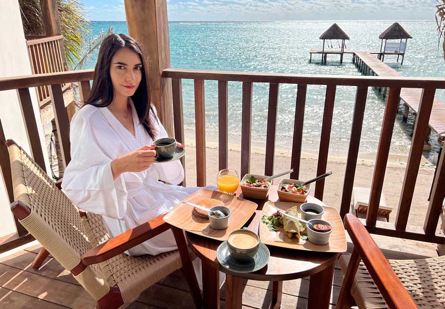 Clara on the beachside balcony in Nerea Tulum with their breakfast meals