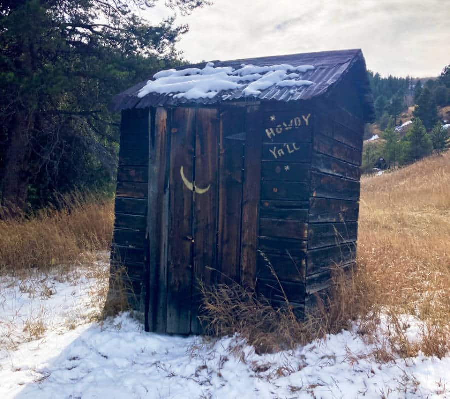 An abandoned wooden structure with snow in the fields of Nevadaville
