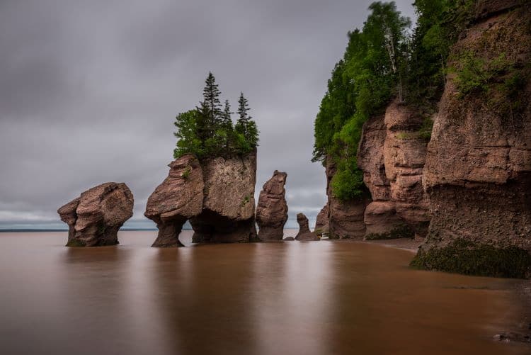 Hopewell rocks tower out of the water while the tide flows in the Bay of Fundy in New Brunswick