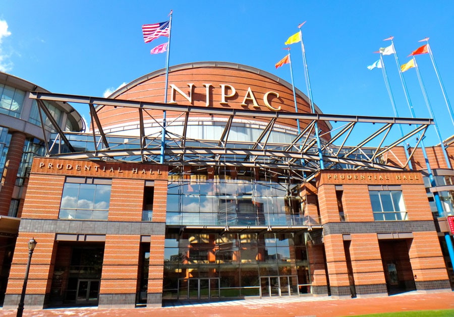 The New Jersey Performing Arts Center from the outside with different flags on it