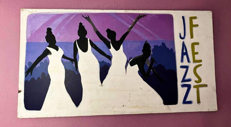 Hand painted poster of women and Jazz Fest signage
