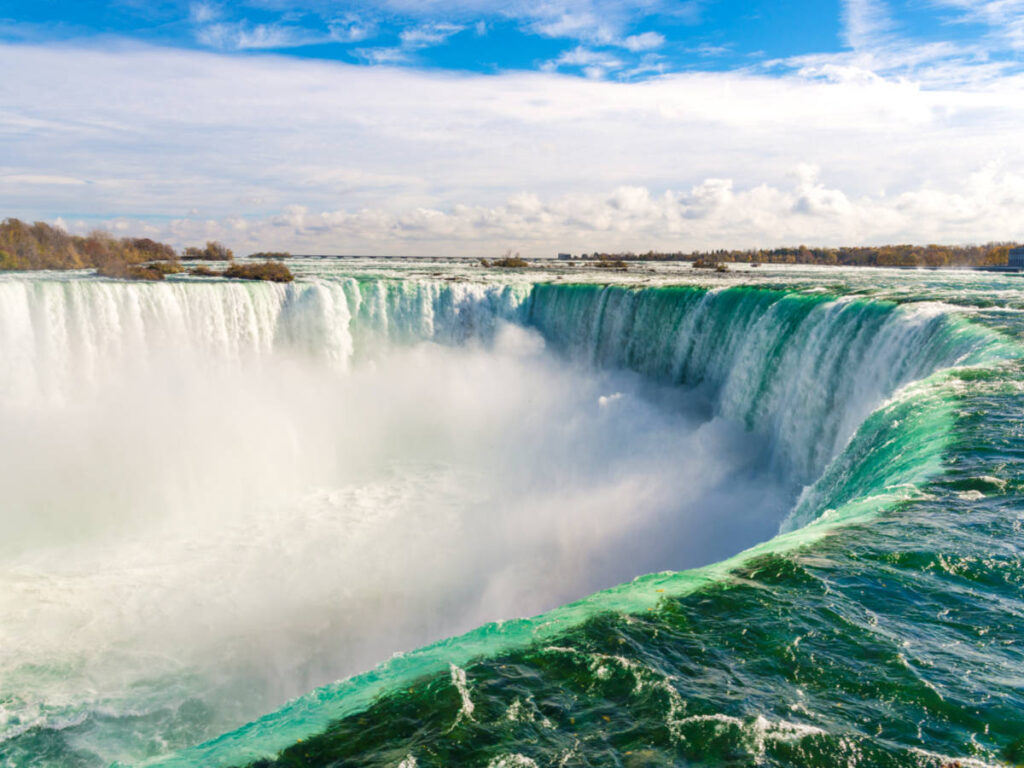 Aerial view of the cascading water of Niagara Falls on a sunny day