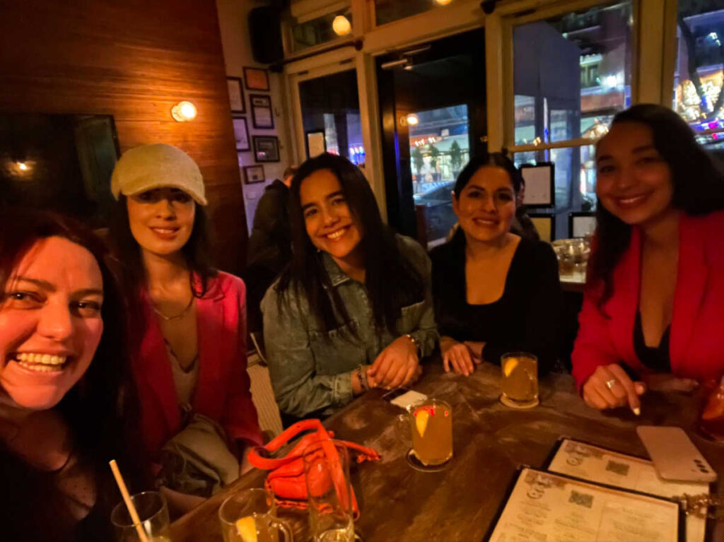 The author Niamh Hayes and her friends, smiling for a photo inside the bar