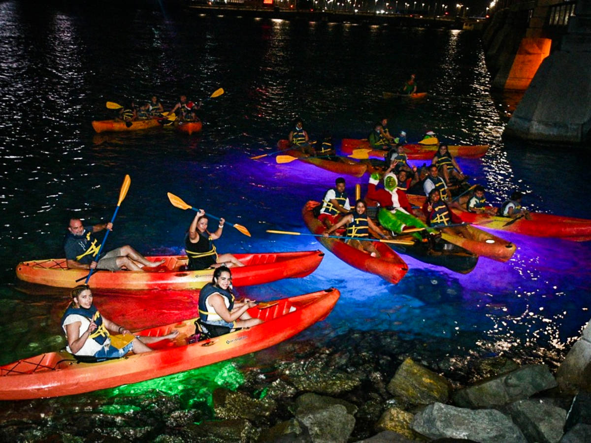 People kayaking in Condado Lagoon at night