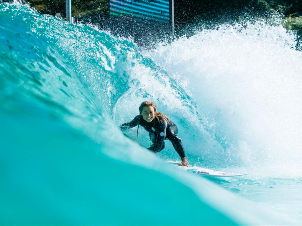 Professional surfer Nikki van Dijk wearing a wetsuit, rides a wave on a surfboard