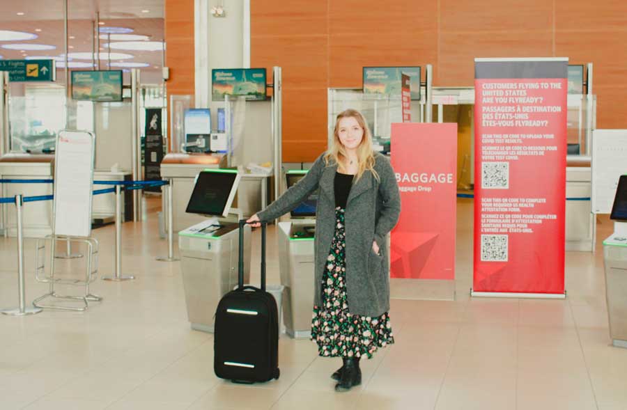 The author holding her Nomatic Navigator Carry on Suitcase