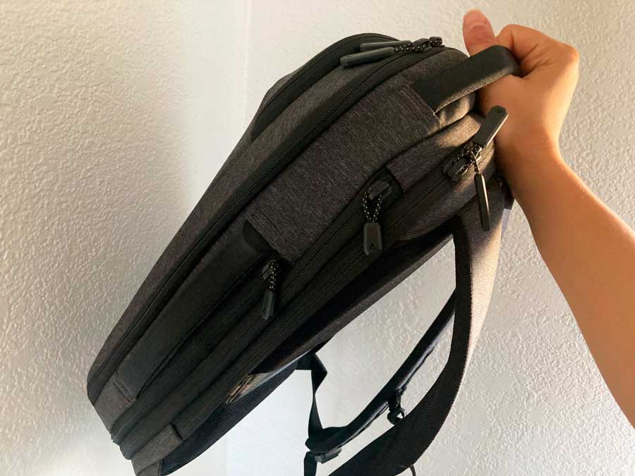 A hand holding the handle of Nomatic Navigator Lite
