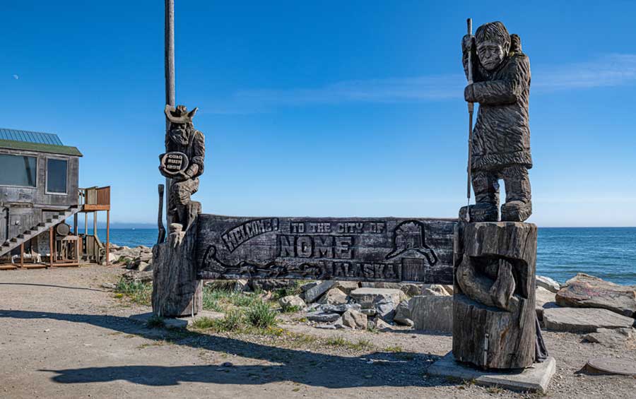 A wooden carved at the welcome sign of Nome
