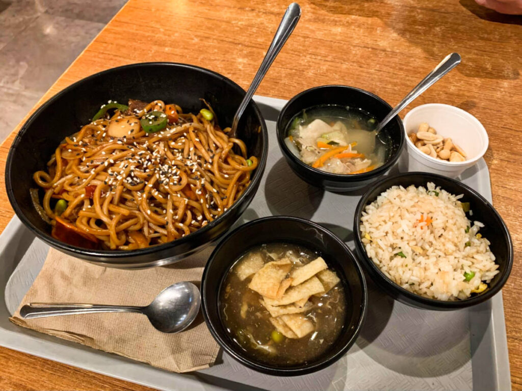 A tray with a huge bowl of noodles with other bowls of soup and rice from Blazin’ Mongolian BBQ