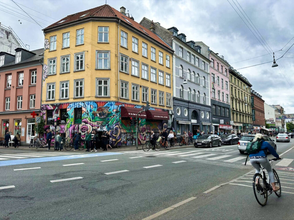 Corner view of the street of Nørrebrogade with the people walking and cycling around