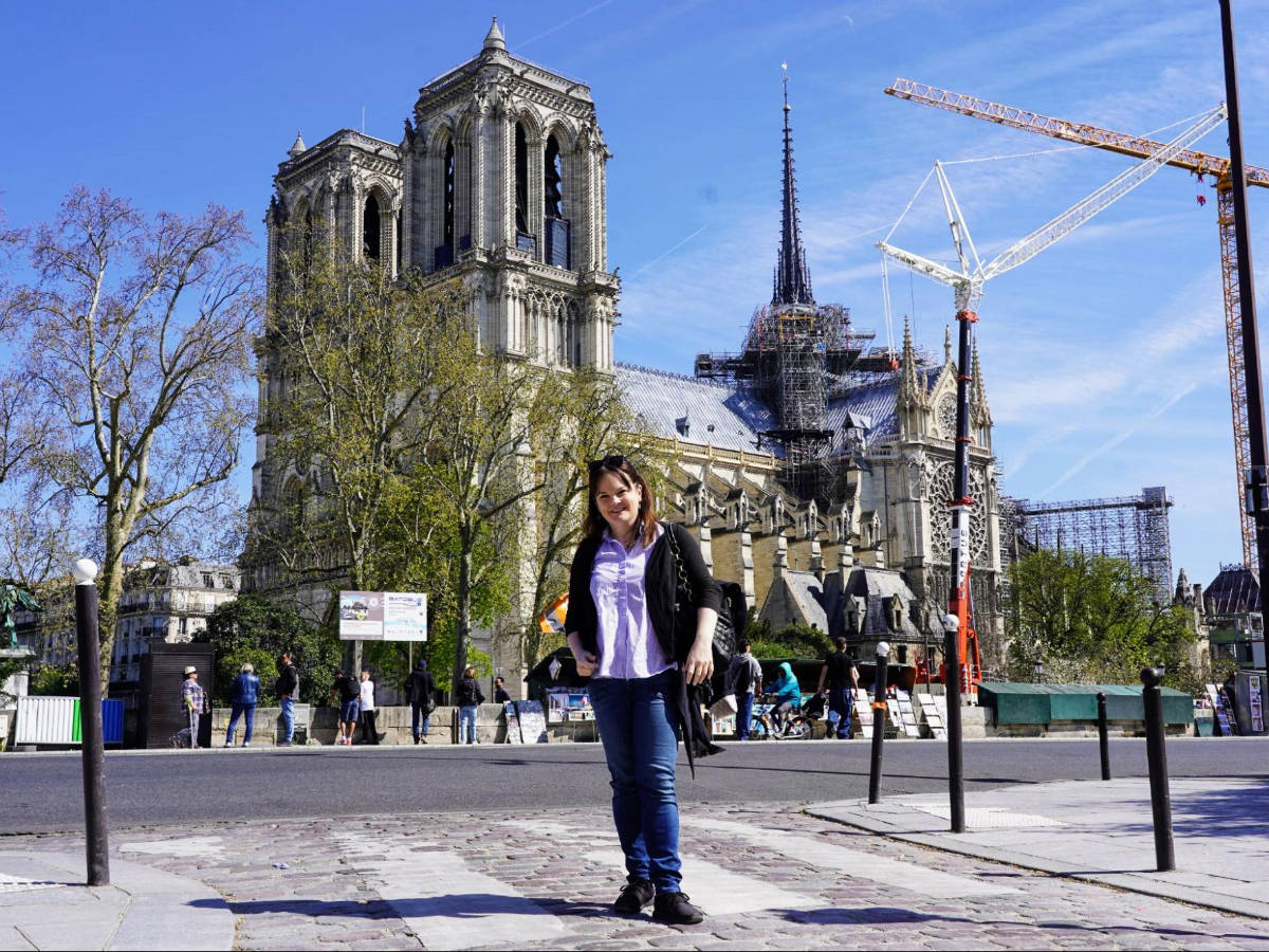 The author Rachel Kapelke-Dale and the Notre Dame construction on her background