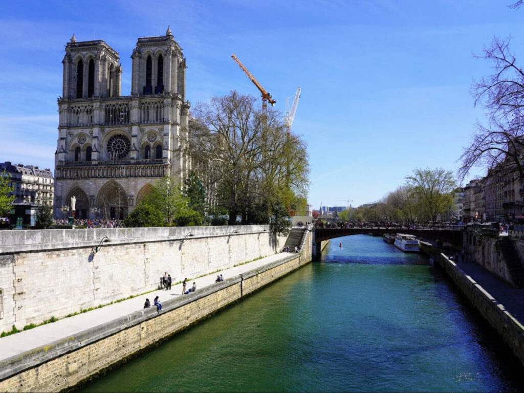 Notre-Dame Cathedral rises on the Île de la Cité in Paris, viewed from across the Seine River