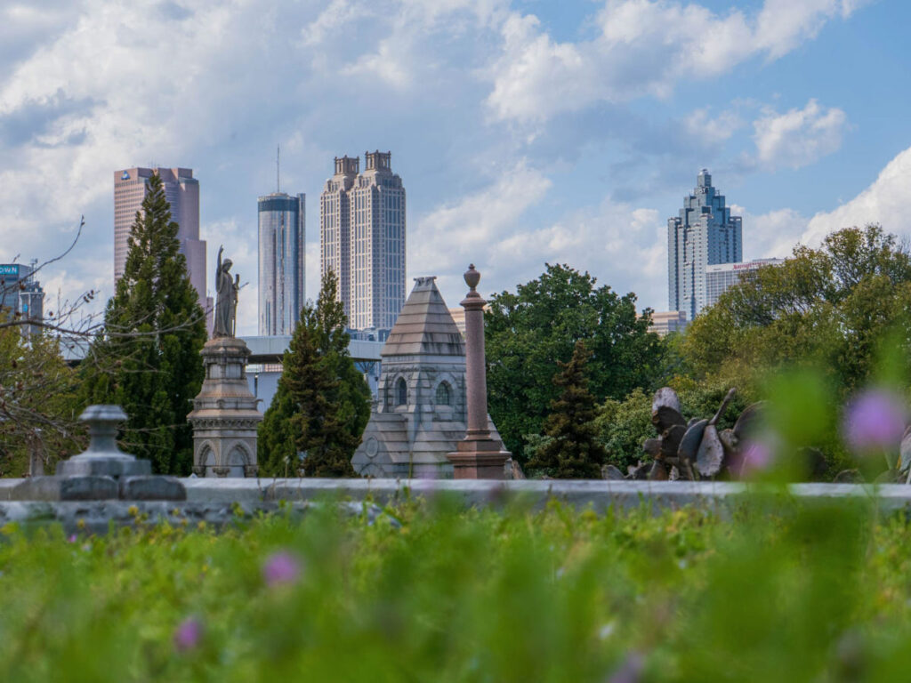 View of the grounds of Oakland Cemetery with the Downtown Atlanta skyline in the distance