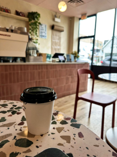 A cup of oat milk latte served on the table at Allez Cafe