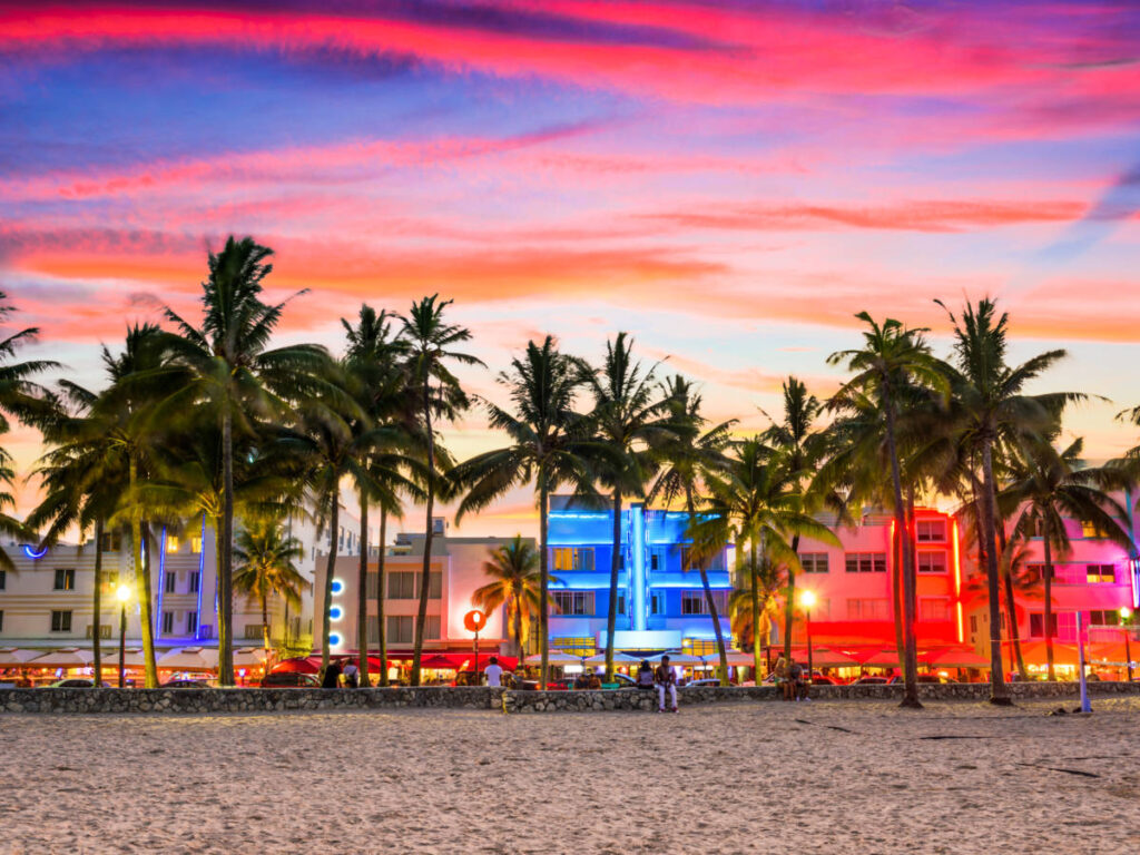 Picturesque view of the pink and red sunset skies over the illuminated buildings at Ocean Drive
